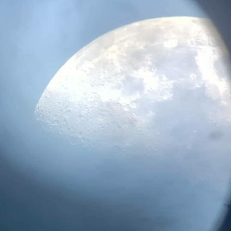 Imagem da Lua feita a partir da lente do telescópio, mostrando detalhes de sua superfície, em observação diurna